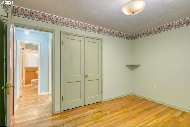 unfurnished bedroom featuring light hardwood / wood-style floors, a closet, and a textured ceiling