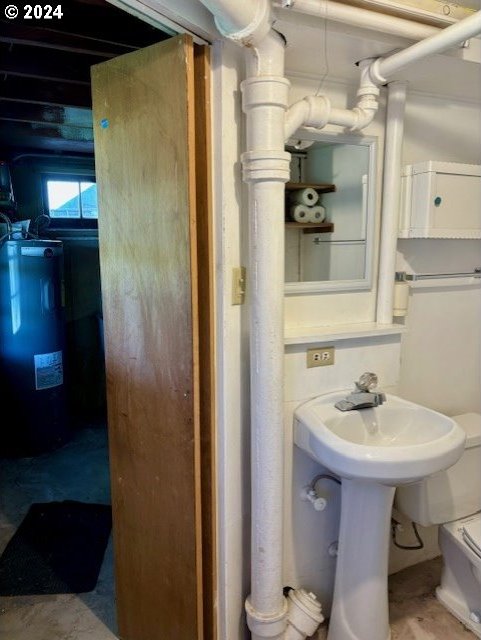 bathroom featuring water heater and toilet