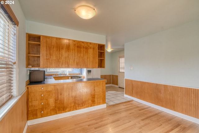 kitchen featuring plenty of natural light, light hardwood / wood-style floors, sink, and kitchen peninsula