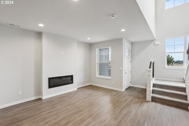 unfurnished living room featuring hardwood / wood-style floors and plenty of natural light