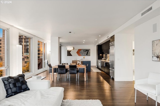 living room with plenty of natural light and dark hardwood / wood-style flooring