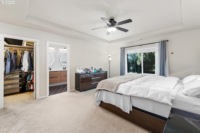 bedroom featuring a tray ceiling, a walk in closet, and a closet