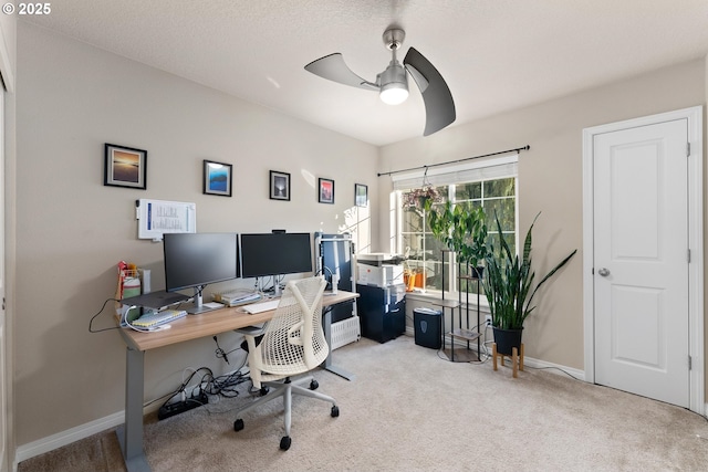 carpeted home office featuring ceiling fan