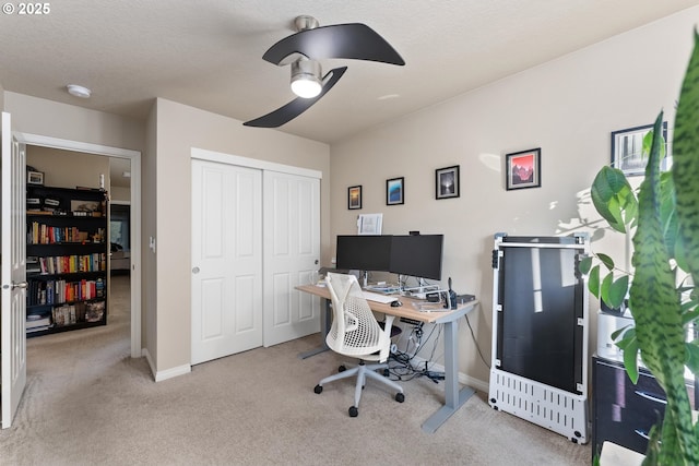 office space featuring light carpet, a textured ceiling, and ceiling fan