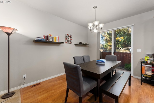 dining room with an inviting chandelier and light hardwood / wood-style flooring