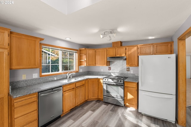 kitchen featuring electric range oven, dishwasher, sink, white fridge, and light wood-type flooring