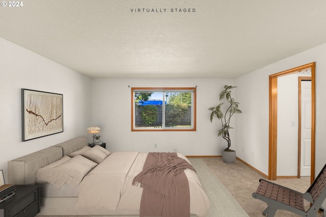 bedroom featuring light carpet and a textured ceiling