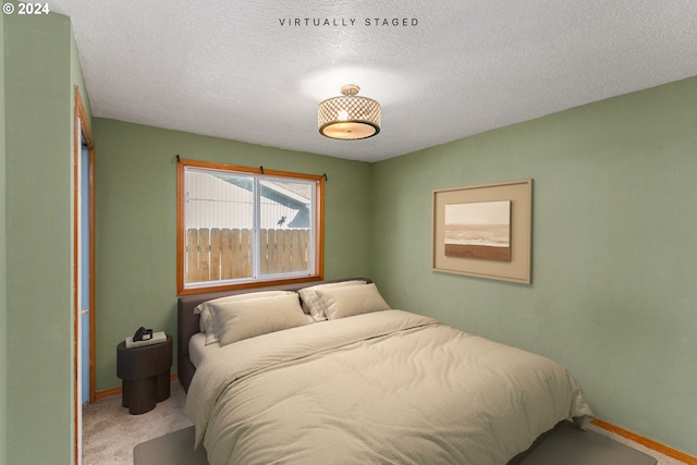 carpeted bedroom featuring a textured ceiling