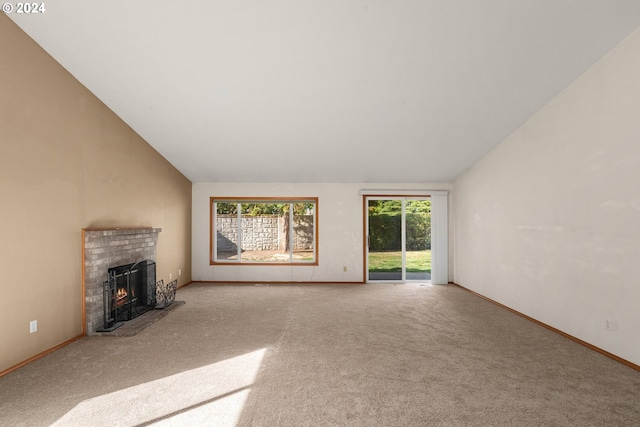 unfurnished living room featuring light carpet, a brick fireplace, and vaulted ceiling