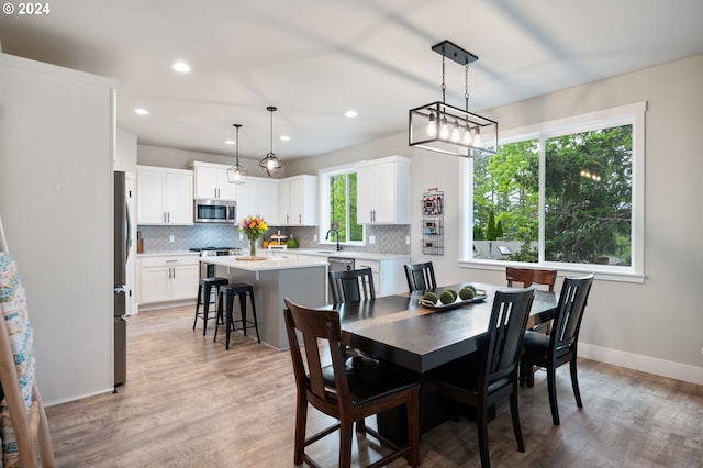 dining room featuring light wood-style flooring, baseboards, and recessed lighting