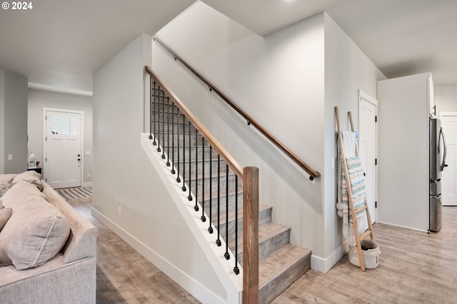 staircase featuring baseboards and wood finished floors