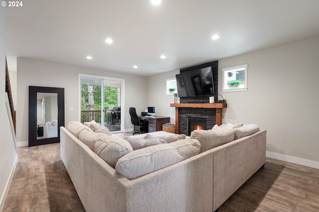 living area featuring a fireplace, baseboards, and recessed lighting