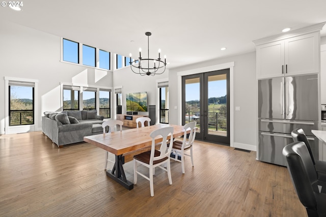 dining area with a wealth of natural light, light wood-type flooring, and french doors