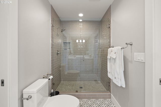 bathroom with a shower with shower door, tile patterned floors, and toilet