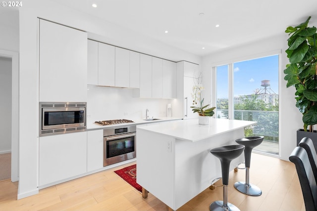 kitchen featuring appliances with stainless steel finishes, modern cabinets, and white cabinets