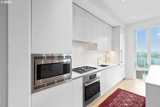 kitchen with light countertops, appliances with stainless steel finishes, modern cabinets, and white cabinetry