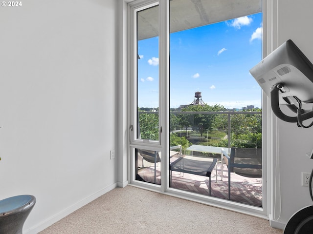 doorway to outside featuring carpet floors and baseboards