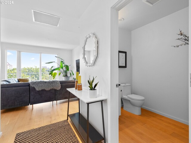 bathroom with toilet and hardwood / wood-style flooring