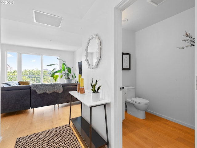 bathroom featuring visible vents, wood finished floors, toilet, and baseboards