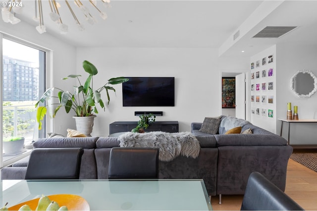 living area featuring visible vents and wood finished floors