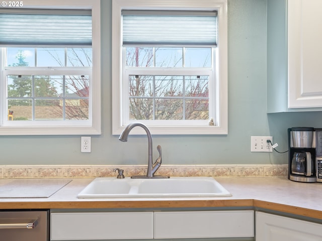 kitchen with sink, a wealth of natural light, and white cabinets