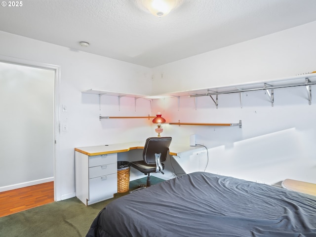 bedroom featuring dark carpet and a textured ceiling