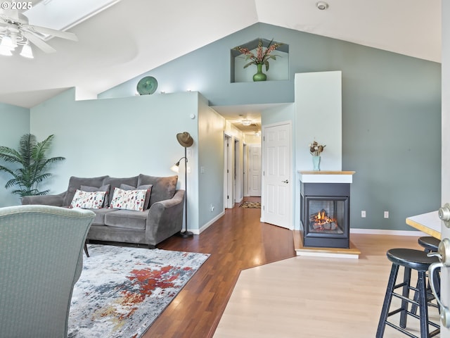 living room featuring ceiling fan, high vaulted ceiling, and dark hardwood / wood-style flooring