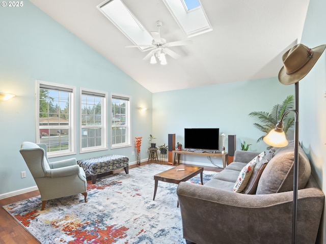 living room featuring hardwood / wood-style flooring, ceiling fan, high vaulted ceiling, and a skylight