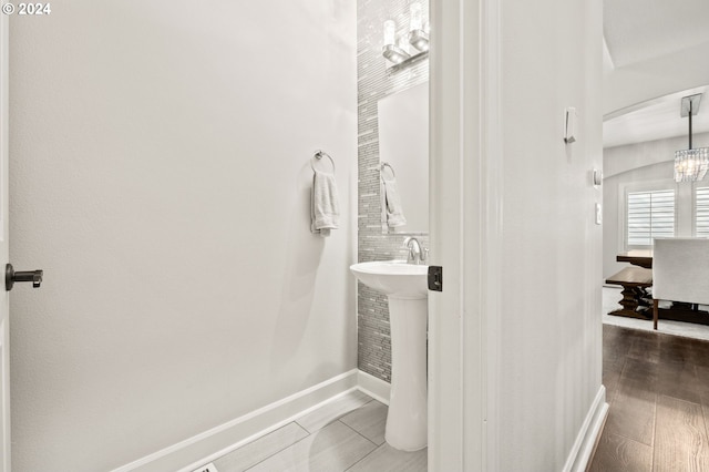 bathroom featuring an inviting chandelier and hardwood / wood-style flooring