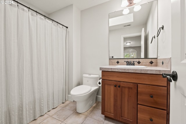 bathroom with vanity, toilet, tasteful backsplash, and tile patterned floors