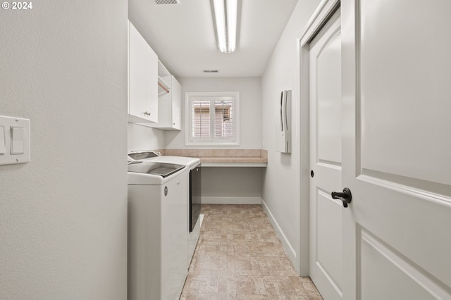 laundry room featuring independent washer and dryer and cabinets