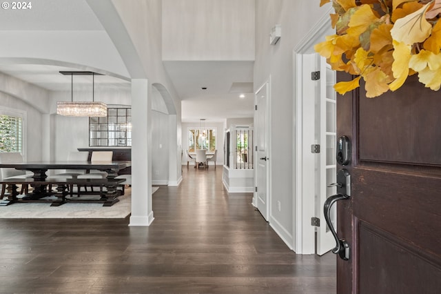 foyer featuring an inviting chandelier and dark hardwood / wood-style flooring