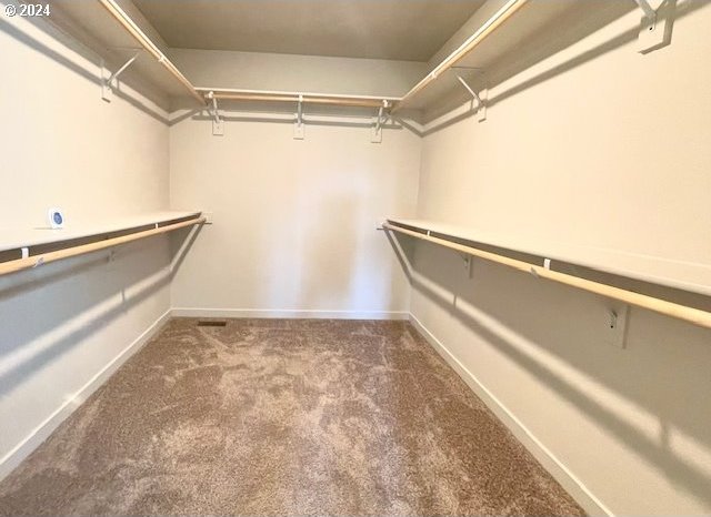 spacious closet featuring dark carpet