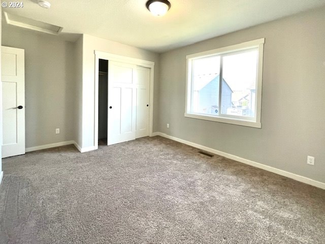 unfurnished bedroom with carpet and a closet