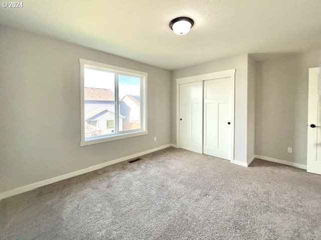 unfurnished bedroom with a closet and carpet floors