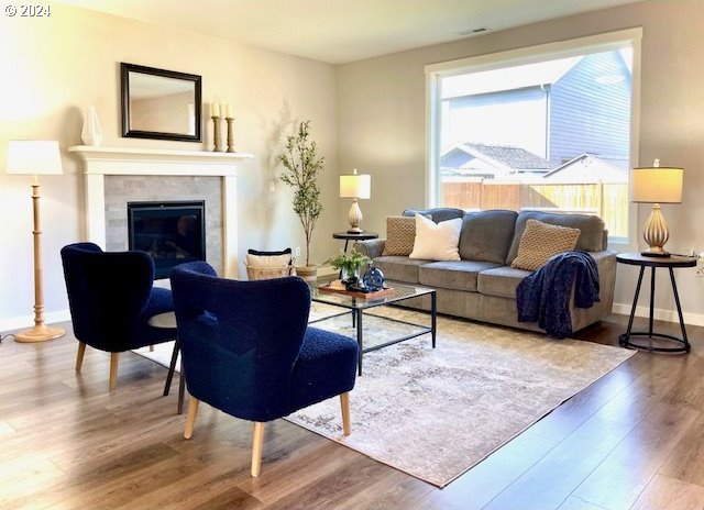 living room with hardwood / wood-style floors and a tile fireplace