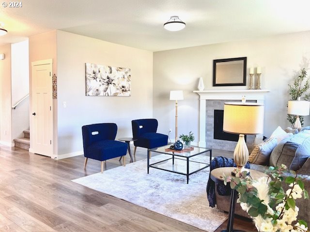 living room featuring hardwood / wood-style floors and a tiled fireplace