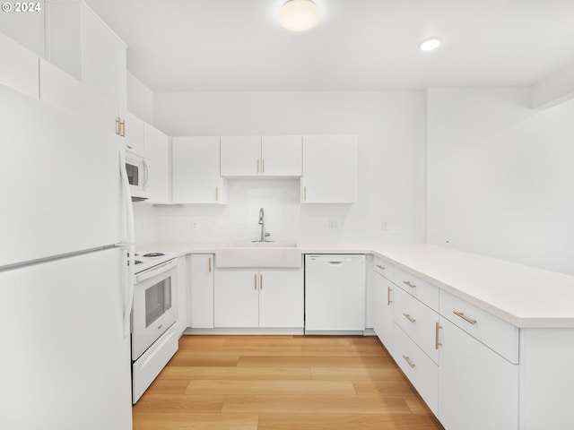 kitchen with backsplash, white cabinetry, light wood-type flooring, sink, and white appliances