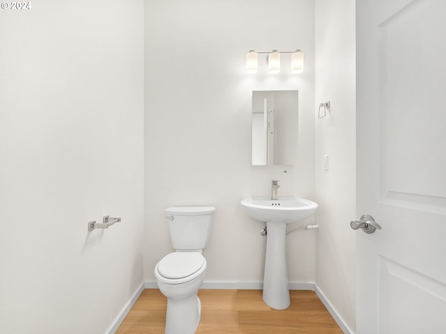 bathroom with toilet and hardwood / wood-style floors