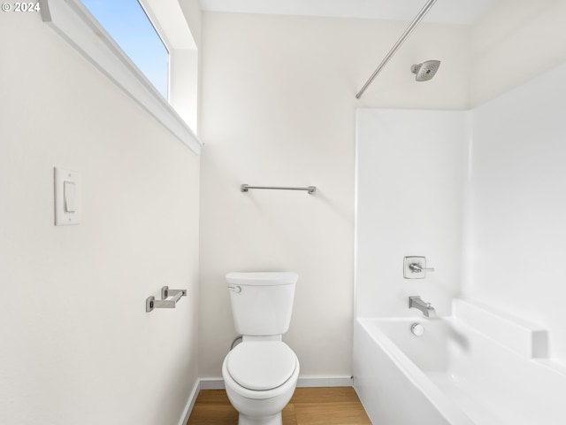 bathroom with wood-type flooring, toilet, and shower / bathtub combination