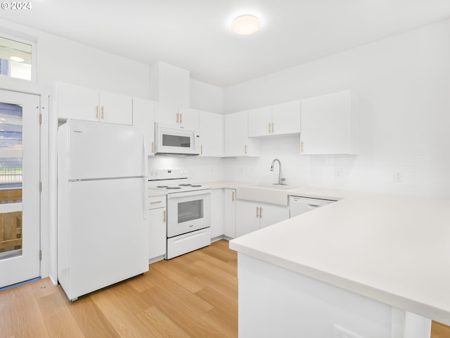 kitchen with white cabinetry, a wealth of natural light, and white appliances