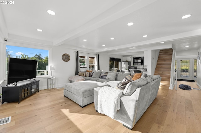 living room with beam ceiling and light hardwood / wood-style flooring