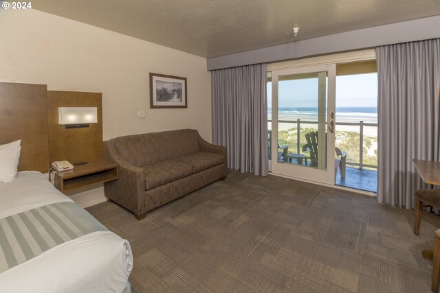 living area with view of water and beach and carpet