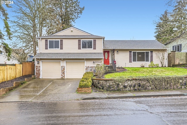 tri-level home with a garage and a front lawn