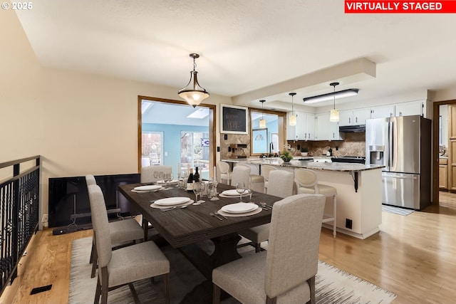 dining area with sink and light hardwood / wood-style flooring