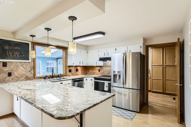 kitchen featuring kitchen peninsula, appliances with stainless steel finishes, white cabinetry, and pendant lighting