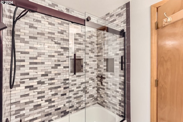 bathroom featuring shower / bath combination with glass door