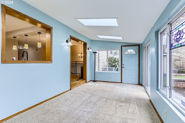 carpeted spare room featuring lofted ceiling with skylight