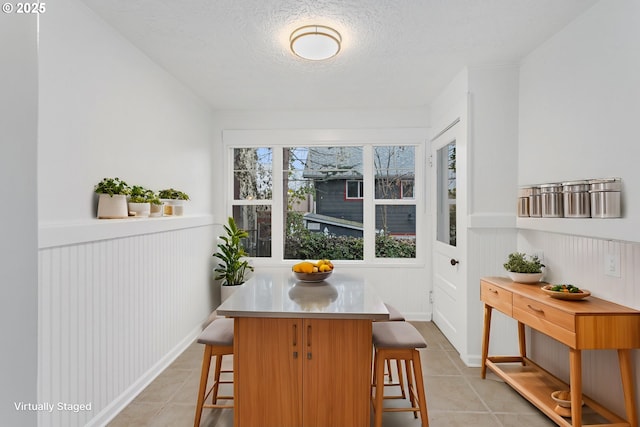 tiled dining area with a textured ceiling