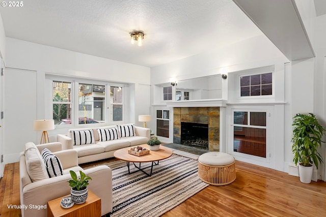 living room featuring wood-type flooring and a tile fireplace